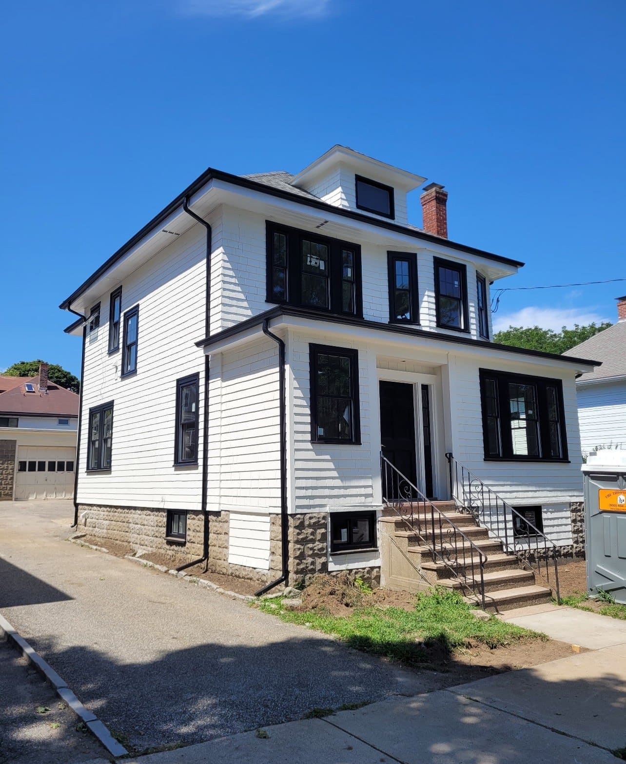 Completed gutter installation on a white colonial home in the Boston area